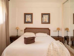 a bedroom with a large white bed with two tables at Ona Garden Lago in Port d'Alcudia +53 photos