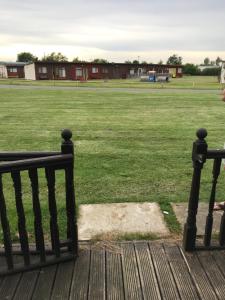 a park with two benches and a field of grass at 2 Bedroom cosy chalet Mablethorpe in Mablethorpe