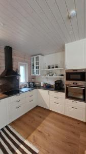 a kitchen with white cabinets and a stove top oven at Kloogaranna Seaside Cottage in Kloogaranna
