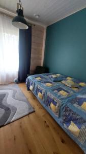 a bedroom with a bed and a blue wall at Kloogaranna Seaside Cottage in Kloogaranna