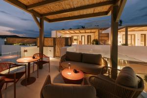 a patio with furniture and tables on a roof at The Lofts Paros Executive Suites in Naousa