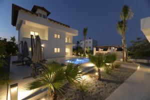 a villa with a swimming pool at night at Azoria Villa in Haraki