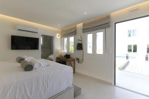 a bedroom with a white bed and a large window at Azoria Villa in Haraki +46 photos