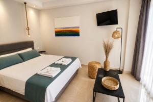 a bedroom with a bed and a table and a tv at Nino Suite, Central Pyrgos in Pyrgos