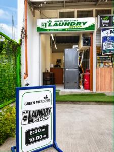 a sign in front of a garage with a green meadows laundry shop at Green Meadows Residence Naga in Milaor +7 photos