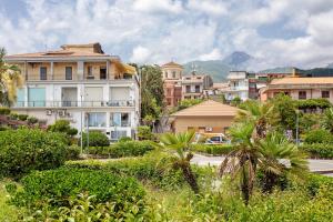 a city with buildings and palm trees and a street at Haddar Etna in Zafferana Etnea