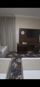 a room with a couch and a desk and a clock at فندق روشن كدي in Al Masfalah