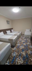 a room with several beds and a carpet at فندق روشن كدي in Al Masfalah