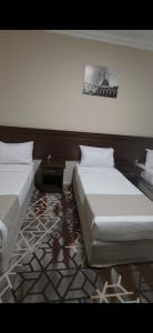 two beds sitting next to each other in a bedroom at فندق روشن كدي in Al Masfalah
