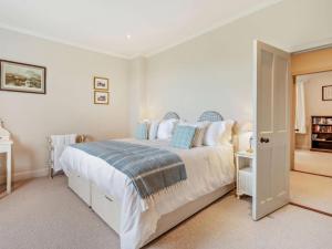 a bedroom with a large white bed with blue pillows at Upper Hillside Cottage in Blairgowrie