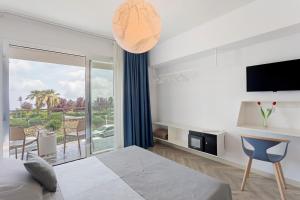 a bedroom with a bed and a tv and a balcony at Haddar Etna in Zafferana Etnea
