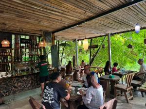 a group of people sitting at a bar at Kung Nok Tha Resort Nakhon Si Thammarat in Nakhon Si Thammarat