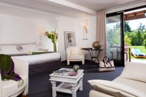 a white living room with a couch and a table at Mangio Fango Hotel et Spa in Saintes-Maries-de-la-Mer