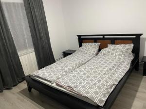 a bed with a black frame and white comforter and pillows at Cabana Elena in Rausor