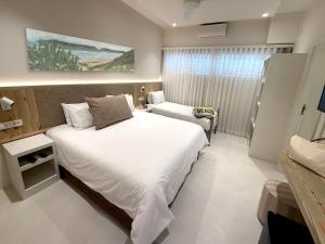 a bedroom with a large white bed and a couch at Plett Beachfront Guest House in Plettenberg Bay +22 photos