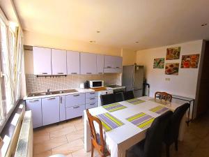a kitchen with white cabinets and a table with chairs at Plein centre de Visé in Visé