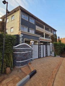 a large house with a garage and a building at Paramount Boutique Hotel in Entebbe