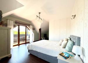a bedroom with a bed and a large window at Biały Dom in Gdańsk