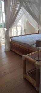 a bedroom with a bed with a white canopy at Villa Residenz am Vulkanradweg in Grebenhain