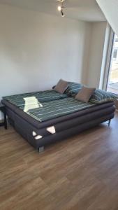 a large bed in a room with a wooden floor at Sonnenstüble in Eriskirch +7 photos