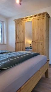 a bedroom with a large bed with a wooden cabinet at Sonnenstüble in Eriskirch