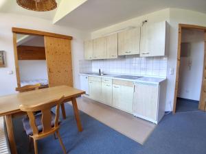 a kitchen with white cabinets and a wooden table at Ferienwohnung Stoll Helga in Burgberg