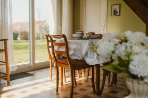 a kitchen with a table with chairs and flowers at Gîte Les Fresnes in Sainte-Honorine-des-Pertes +27 photos