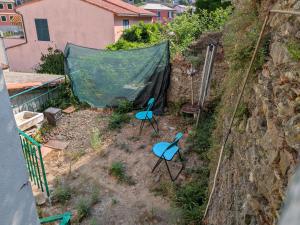 two blue chairs sitting on the side of a hill at Affittacamere Pietra Lucente in Riomaggiore