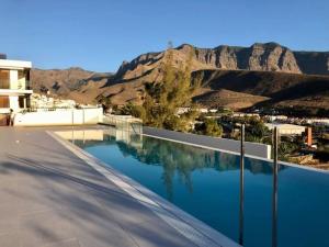 a swimming pool with a view of the mountains at Paraísos de Agaete in Puerto de las Nieves