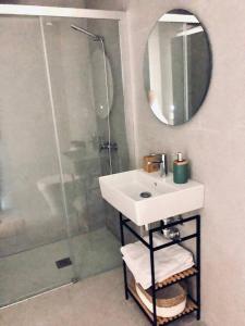 a bathroom with a sink and a shower with a mirror at Paraísos de Agaete in Puerto de las Nieves +22 photos
