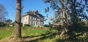 an old house in a field with trees at Kermaria la maison d'hôtes in Plougrescant