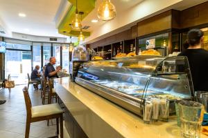 a restaurant with a counter with a buffet of food at Alda Altiana in Ourense