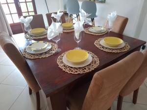 a dining room table with yellow plates and glasses on it at Chalet vue mer, piscine in Saint-Claude