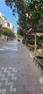 a street with benches and trees on a sidewalk at Nino Suite, Central Pyrgos in Pyrgos