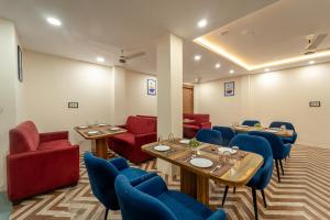 a dining room with tables and blue chairs at Treebo Golden Palm, Civil Lines in Jabalpur