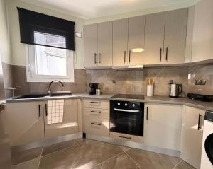 a kitchen with white cabinets and a sink at Bistro 49 Luxury suites in Katerini
