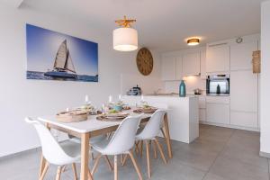 a kitchen and dining room with a white table and chairs at Whaaw Oostende in Ostend