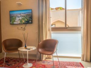 two chairs and a table in a room with a window at Riad Timija in Marrakesh