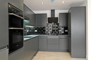 a kitchen with white cabinets and black appliances at Kirkton House in Kirkton of Skene +41 photos