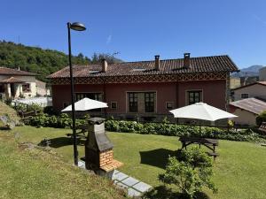 a house with tables and umbrellas in front of it at Vivienda Vacacional La Cocada VV-144-AS in Arriondas