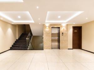 an empty lobby with stairs and a door at Hotel Park Premium With Restaurant & Banquet Ujjain - By D S Stay Group in Ujjain