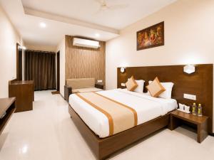 a hotel room with a bed and a desk at Hotel Park Premium With Restaurant & Banquet Ujjain - By D S Stay Group in Ujjain +16 photos