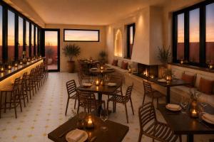 a restaurant with tables and chairs and windows at Riad Maison Palmier in Marrakesh