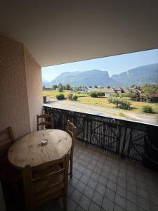 a table and chairs on a balcony with a view at Paisible studio fonctionnel in Cluses
