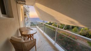 a balcony with a table and chairs and a view of the ocean at Kineta Prime Suites No1 in Kineta