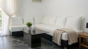 a living room with a white couch and a table at Kineta Prime Suites No1 in Kineta