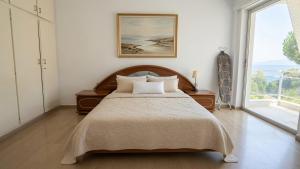 a bedroom with a bed and a large window at Kineta Prime Suites No1 in Kineta