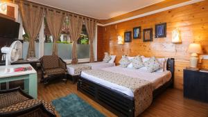 a bedroom with a bed and a table and chairs at De Rock Jungle Living Resort in Coonoor