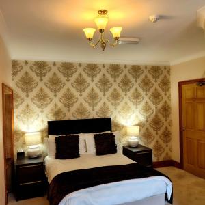 a bedroom with a bed with two night stands and two lamps at Pinewood House in Whitby