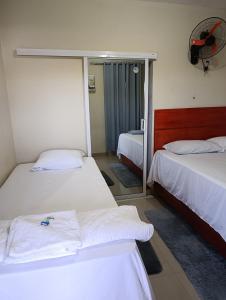 a hotel room with two beds and a fan at Hotel los 4 Tesoros in Pedernales